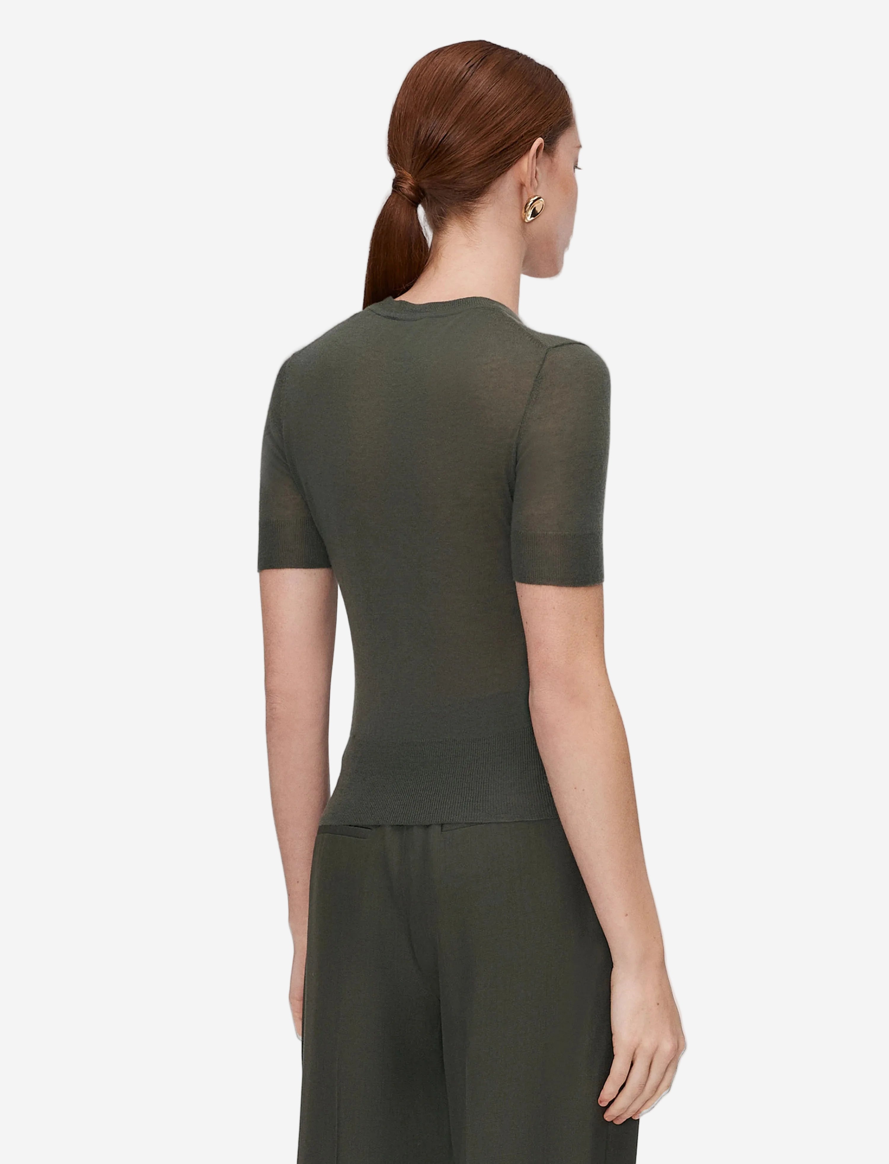 Woman wearing a green dress on a light gray background
