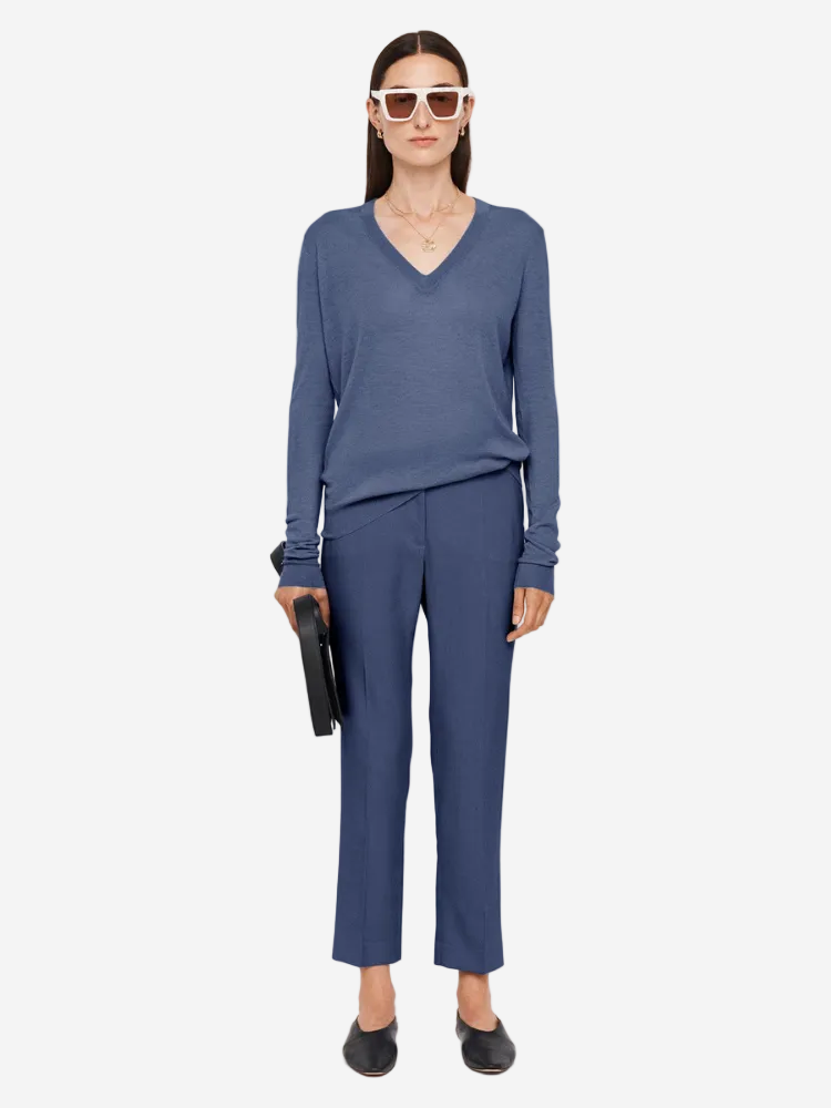 Woman wearing a blue outfit with sunglasses on a white background