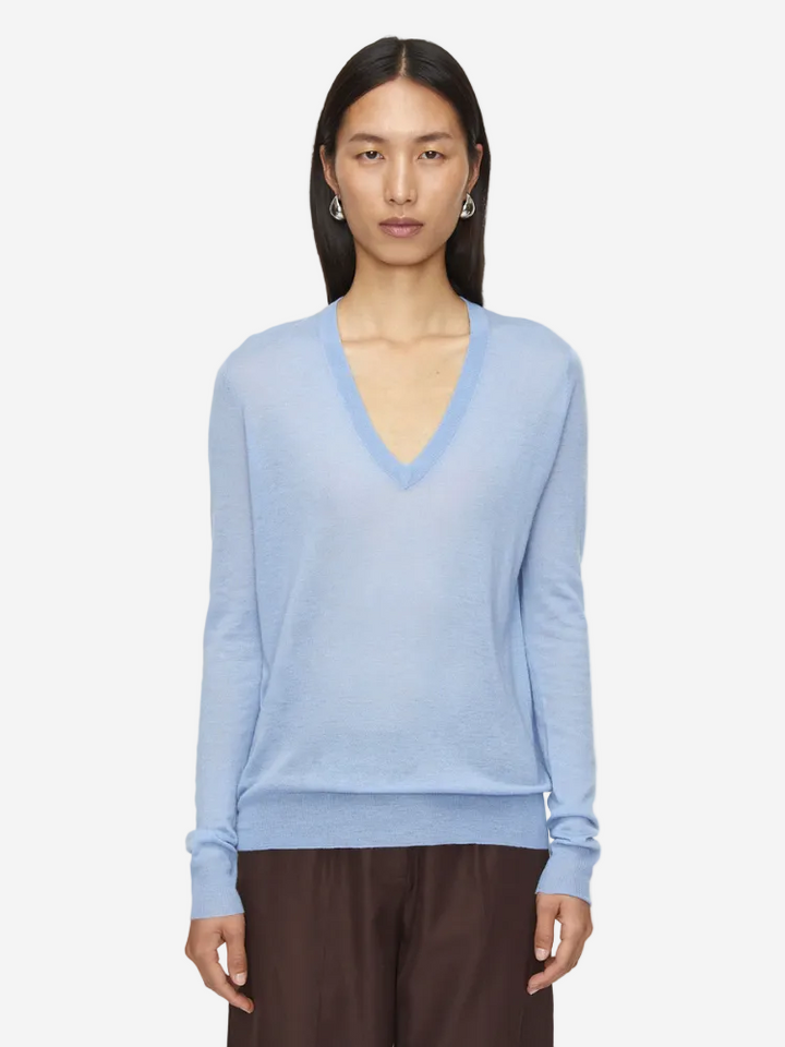 Woman wearing a light blue sweater on a white background