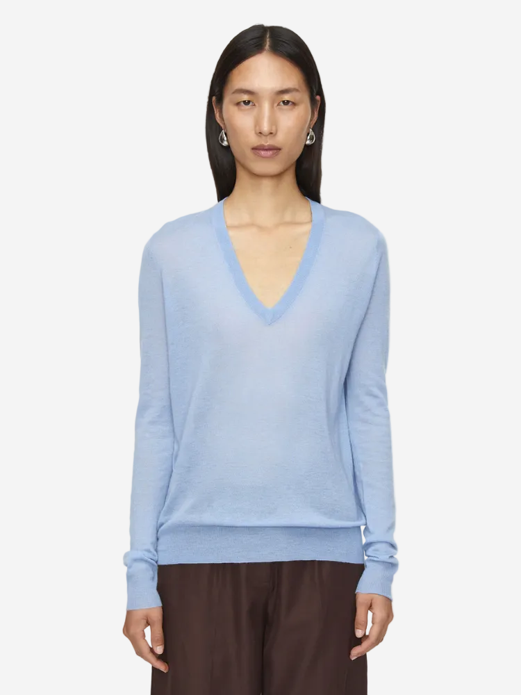 Woman wearing a light blue sweater on a white background