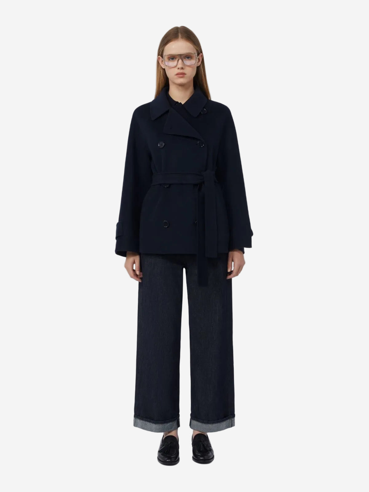 Person wearing a black coat and pants on a white background