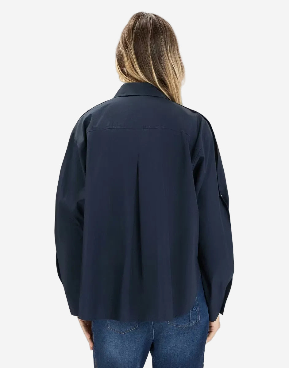 Person wearing a navy blue shirt and jeans on a white background
