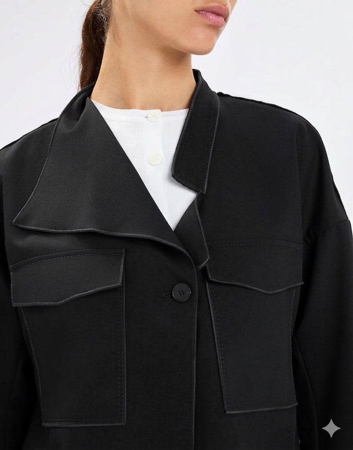 Black jacket worn by a person on a white background