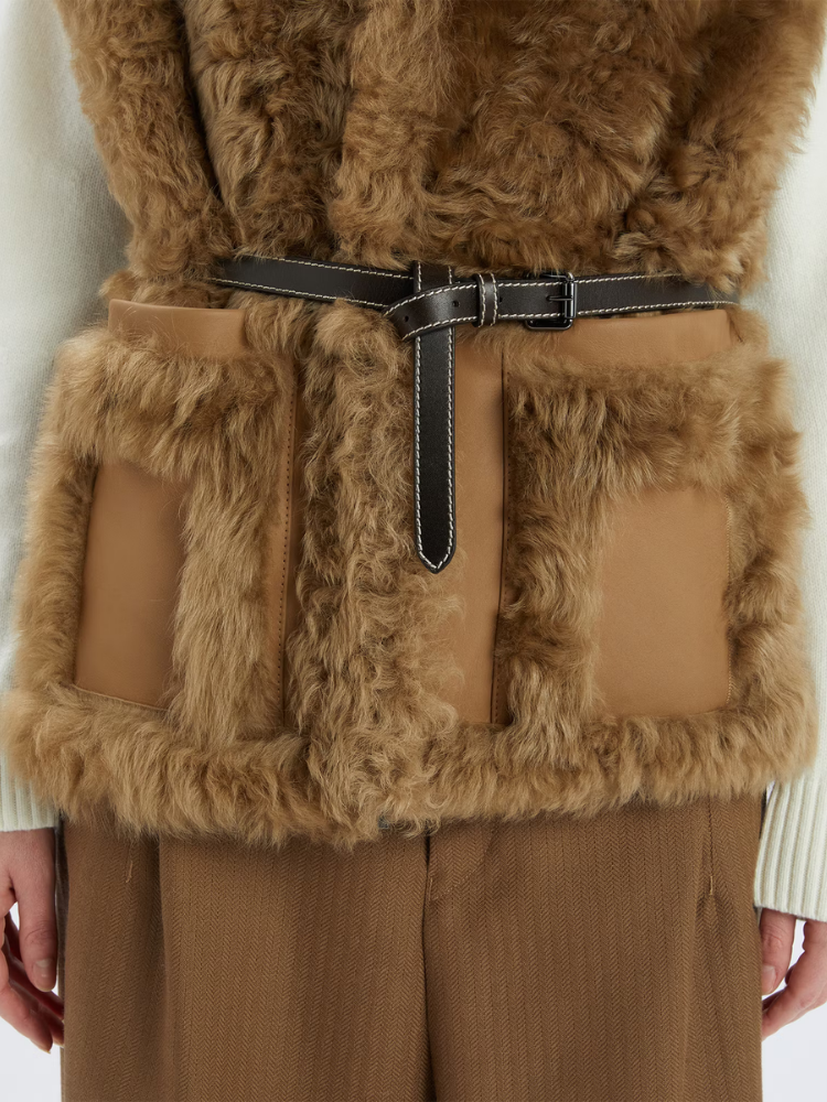 Brown fur vest with a belt on a neutral background