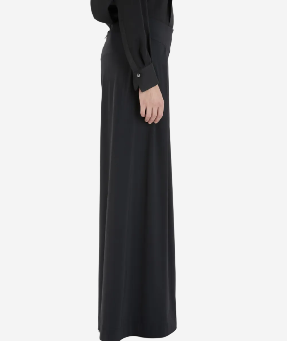 Person wearing a long black skirt on a white background
