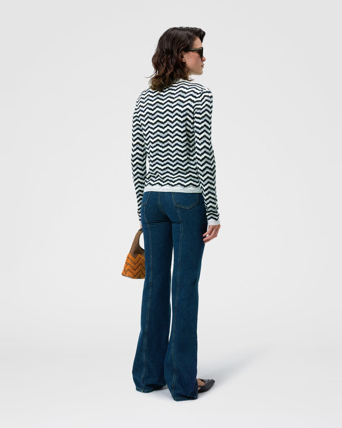 Back view of the Missoni navy and white wave knit cardigan worn with flared jeans