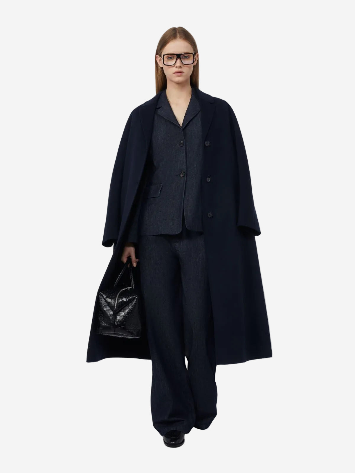 Person wearing a black coat and suit on a white background