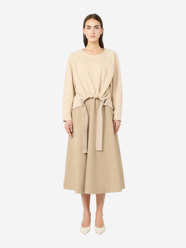 Woman wearing a beige dress with a belt on a white background