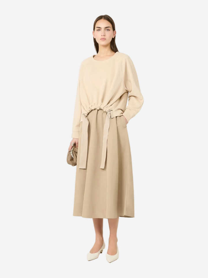Woman wearing a beige dress with a belt on a white background