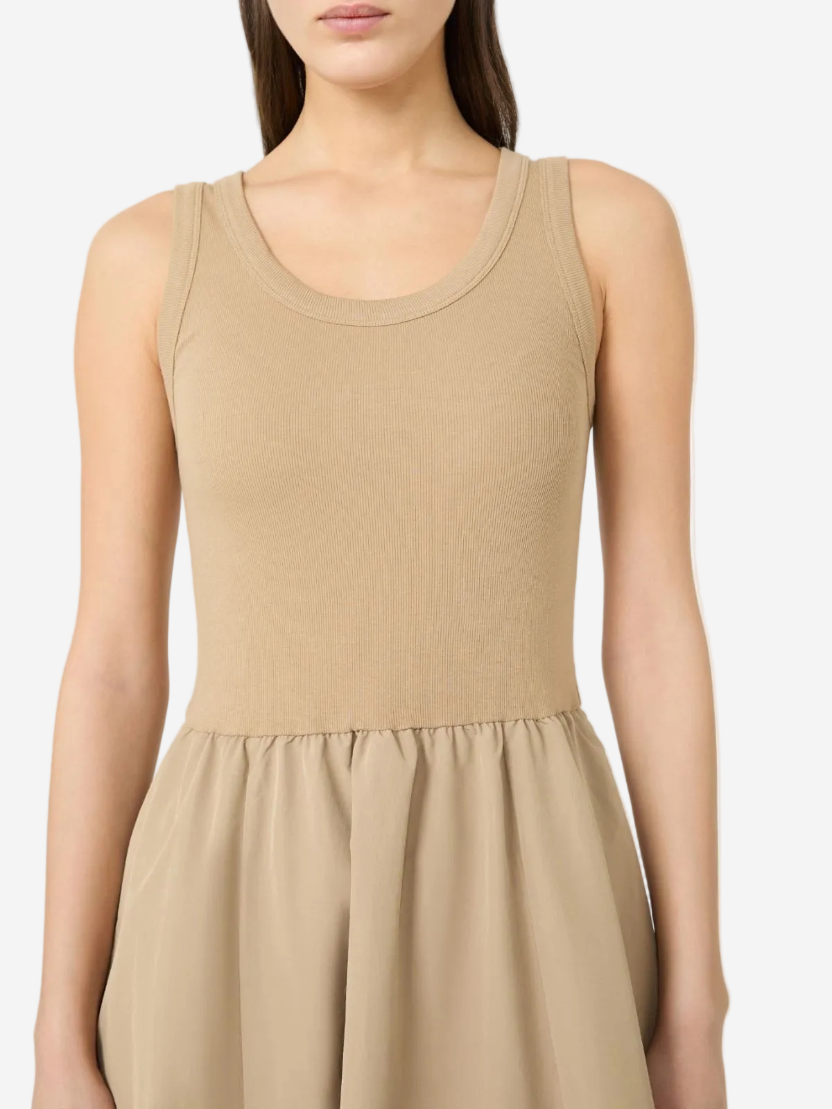 Woman wearing a beige sleeveless dress on a white background