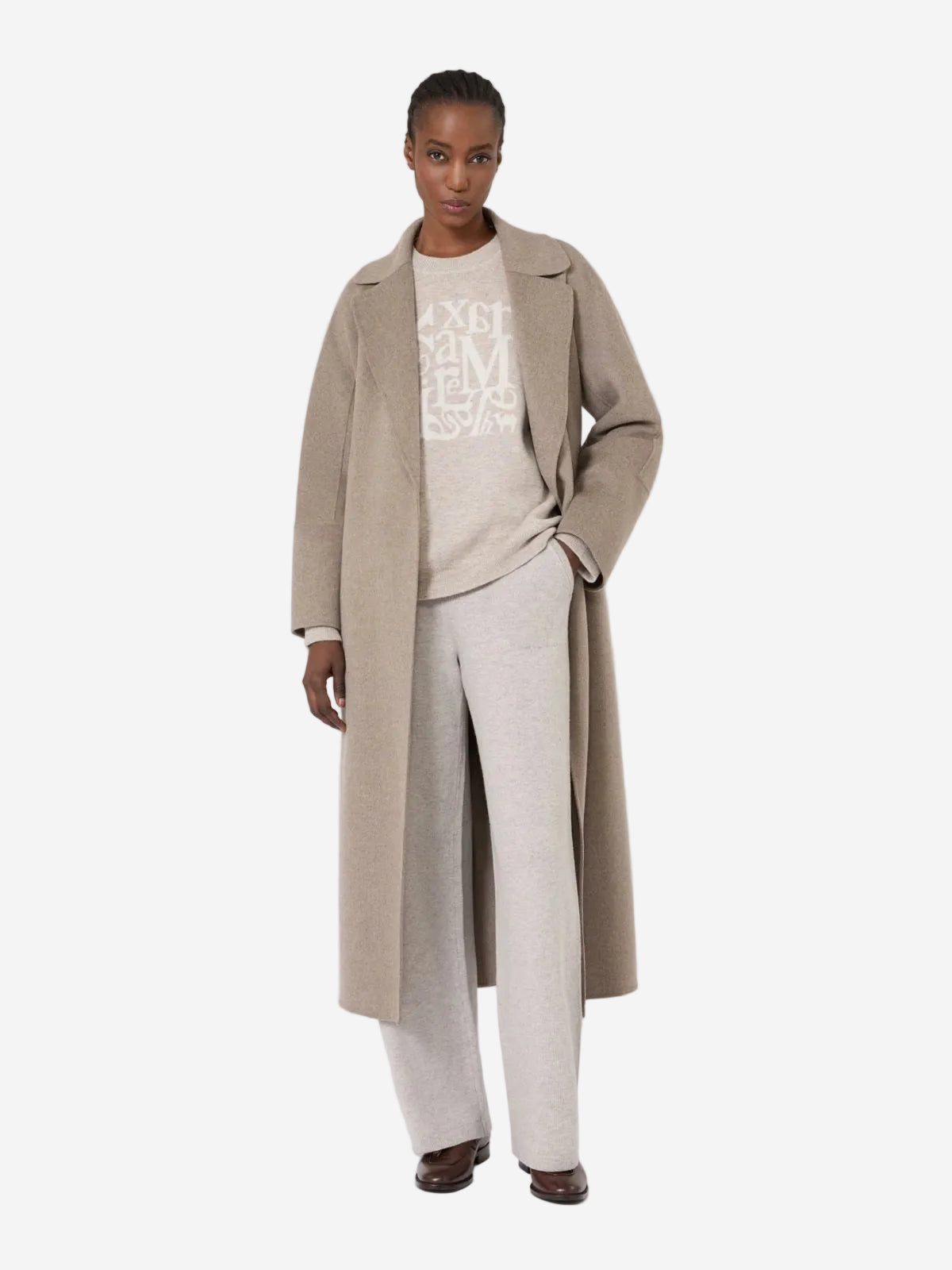 Person wearing a beige coat over a light-colored outfit with text on a white background