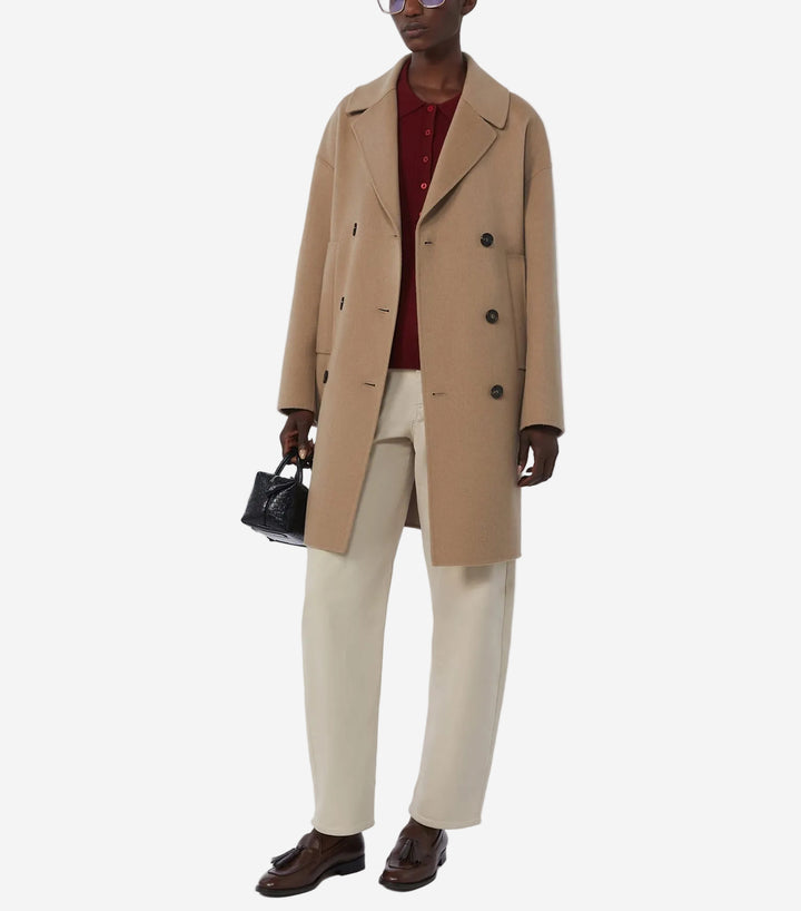 Person wearing a beige coat with a white background