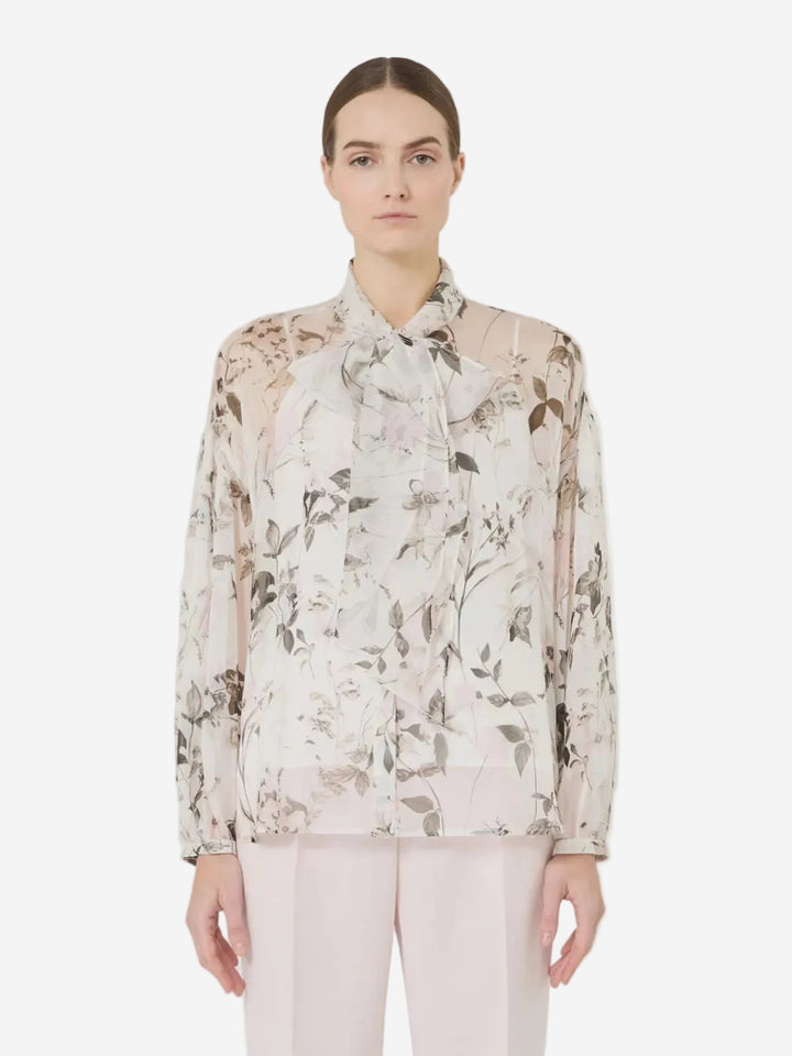 Woman wearing a floral blouse with a plain background