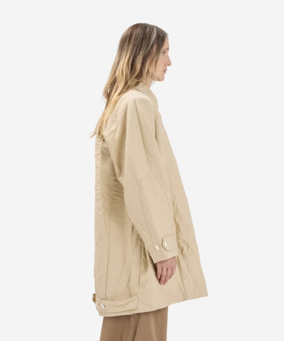 Woman wearing a beige coat on a white background