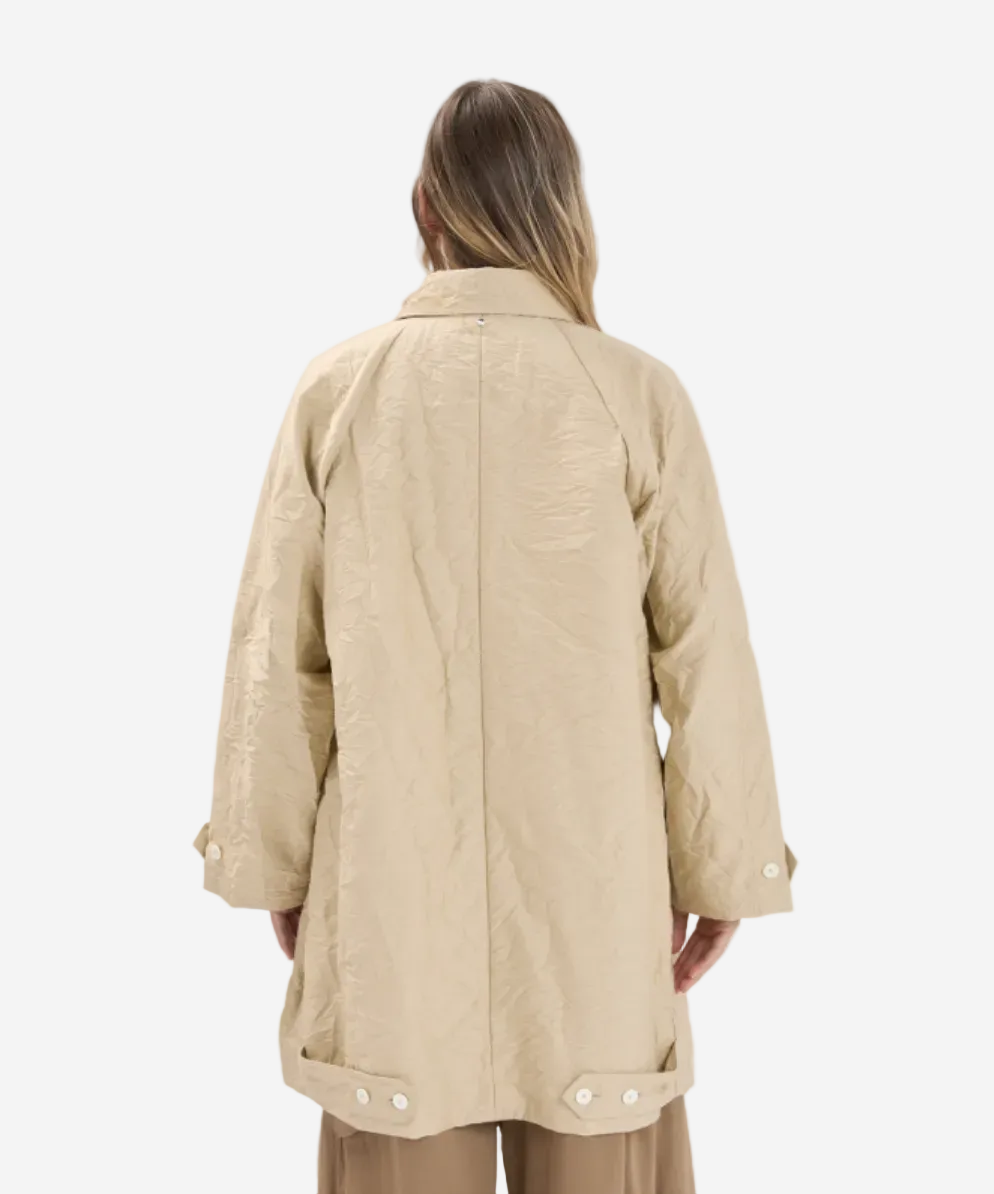Person wearing a beige jacket on a white background