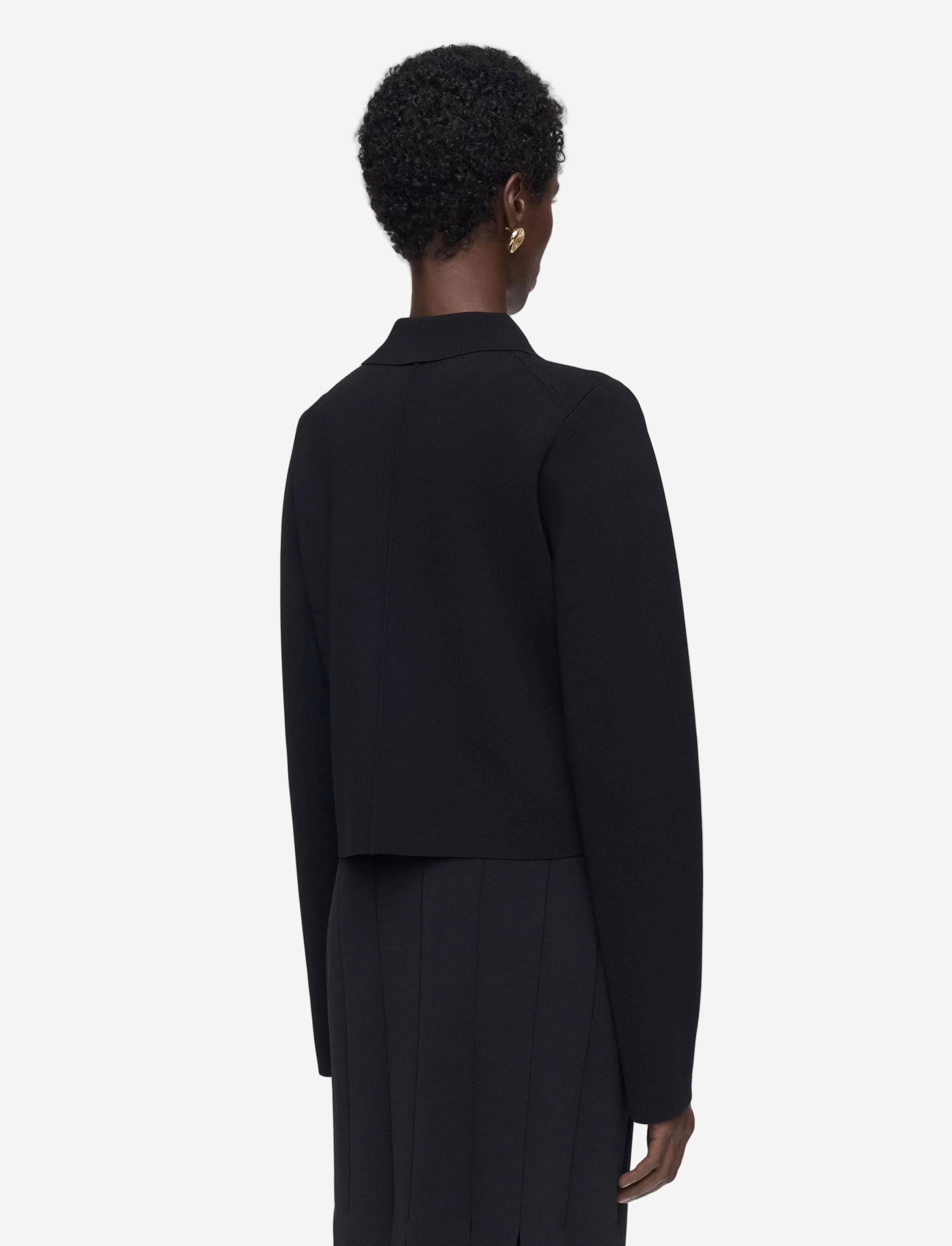 Person wearing a black blazer and pants on a white background