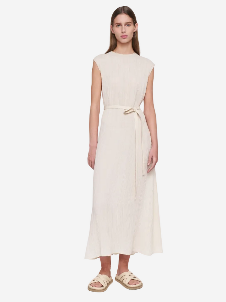Woman wearing a beige sleeveless dress on a white background