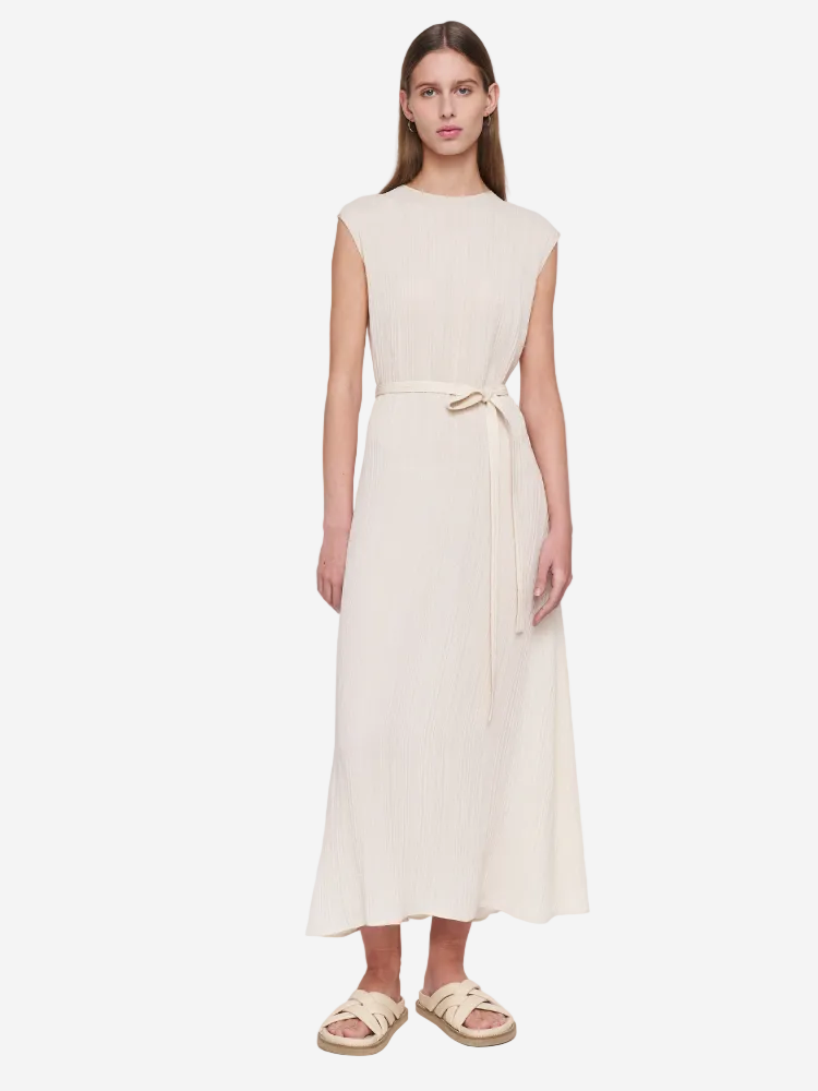 Woman wearing a beige sleeveless dress on a white background
