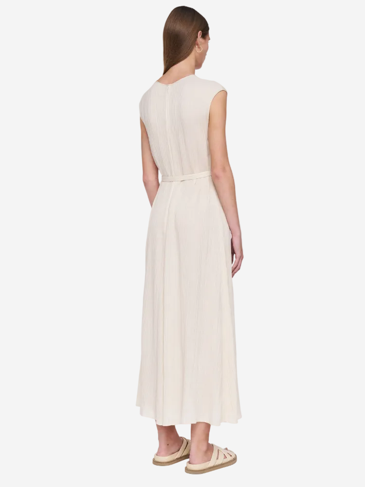 Woman wearing a beige dress against a white background