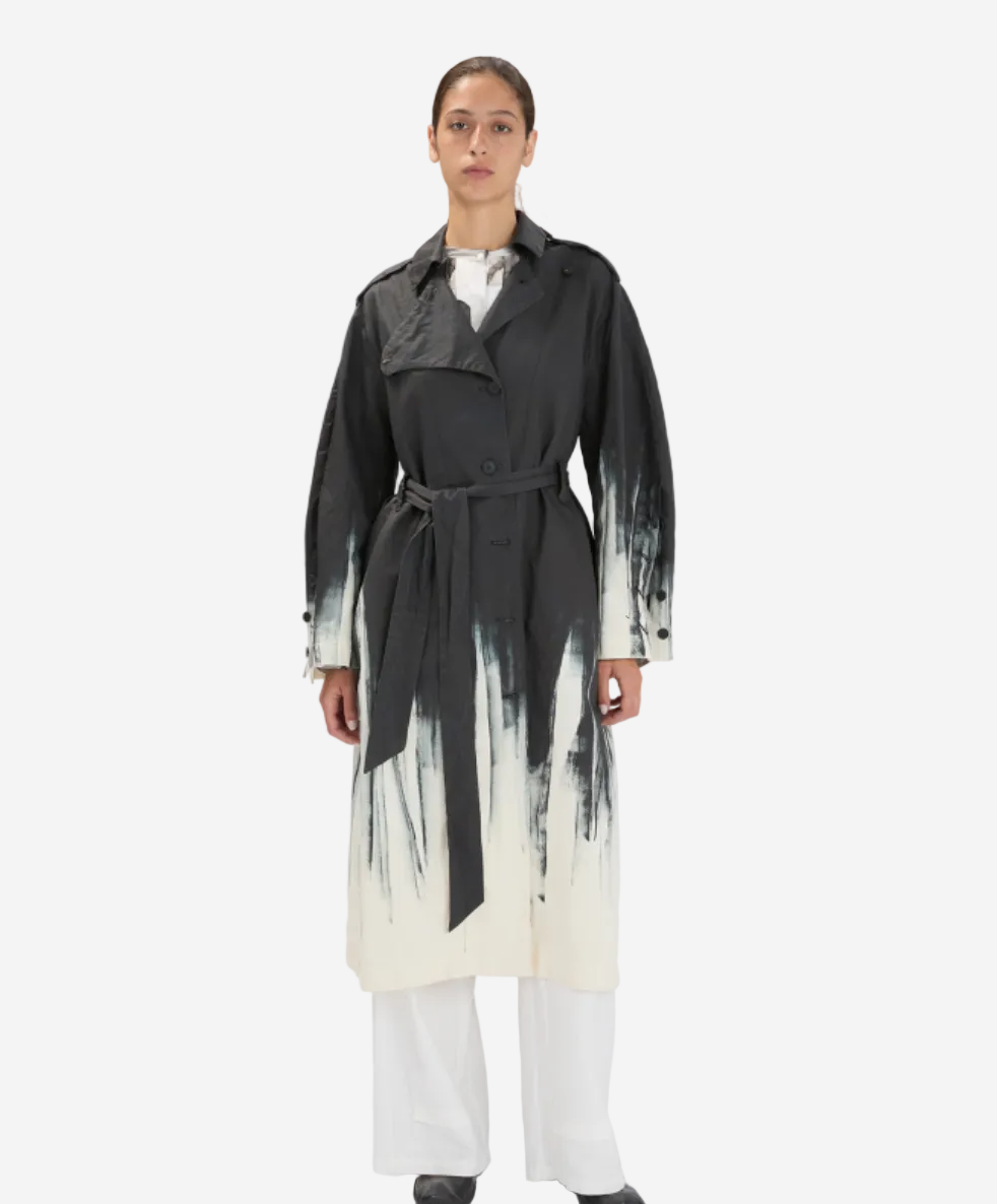 Person wearing a black and white trench coat on a white background