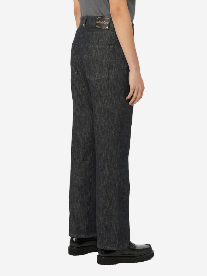Person wearing dark denim jeans on a white background