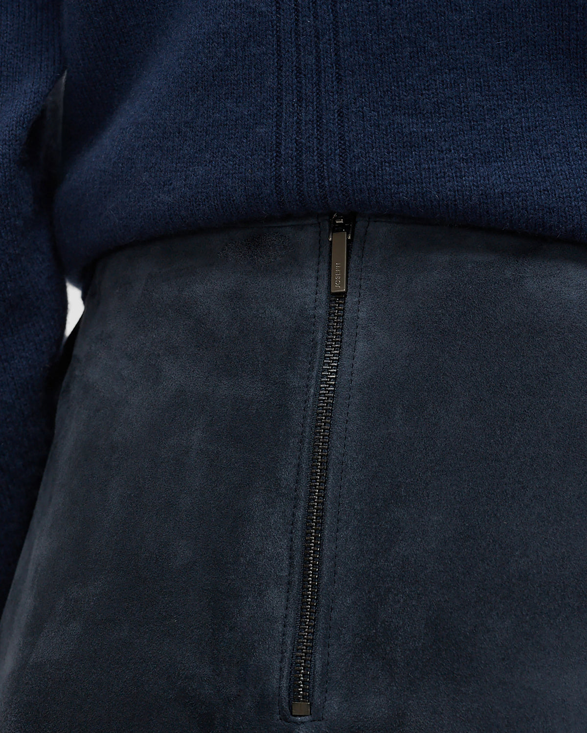 Close up of zipper on long blue leather suede skirt. 