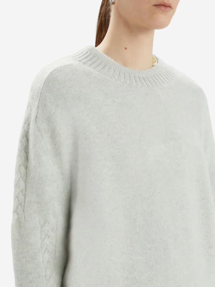 Light gray sweater worn by a person on a white background