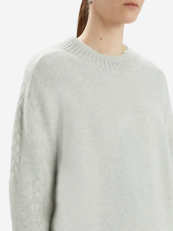 Light gray sweater worn by a person on a white background