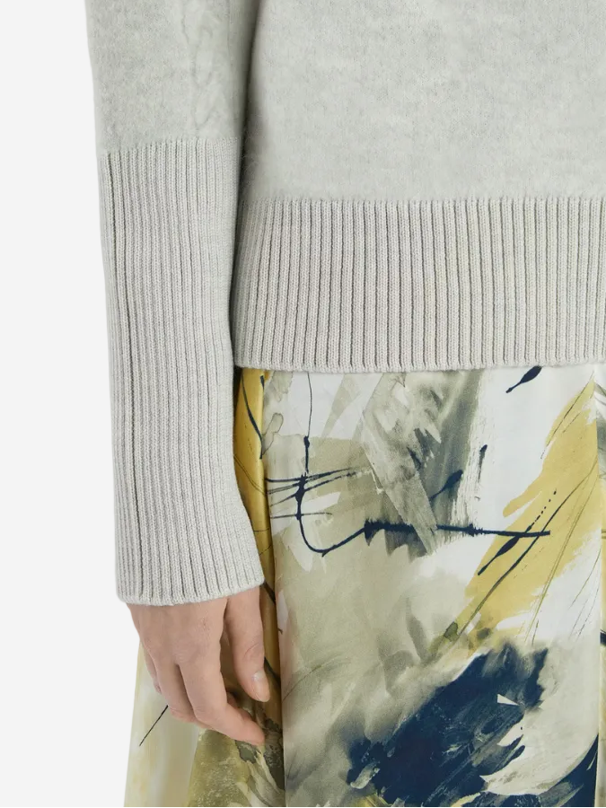 Gray sweater and abstract patterned skirt on a white background