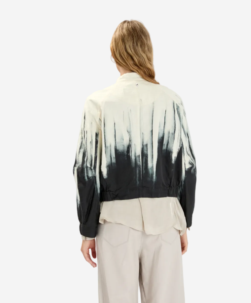 Person wearing a black and white tie-dye shirt with a plain background