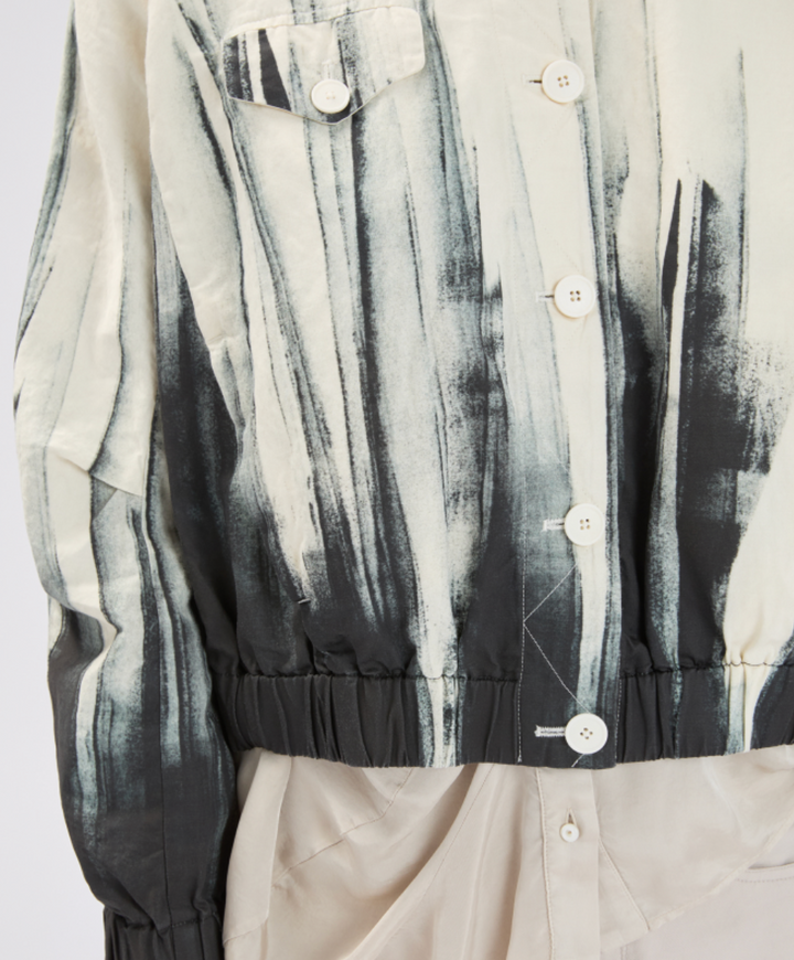 Close-up of a patterned shirt with black, white, and gray design on a plain background