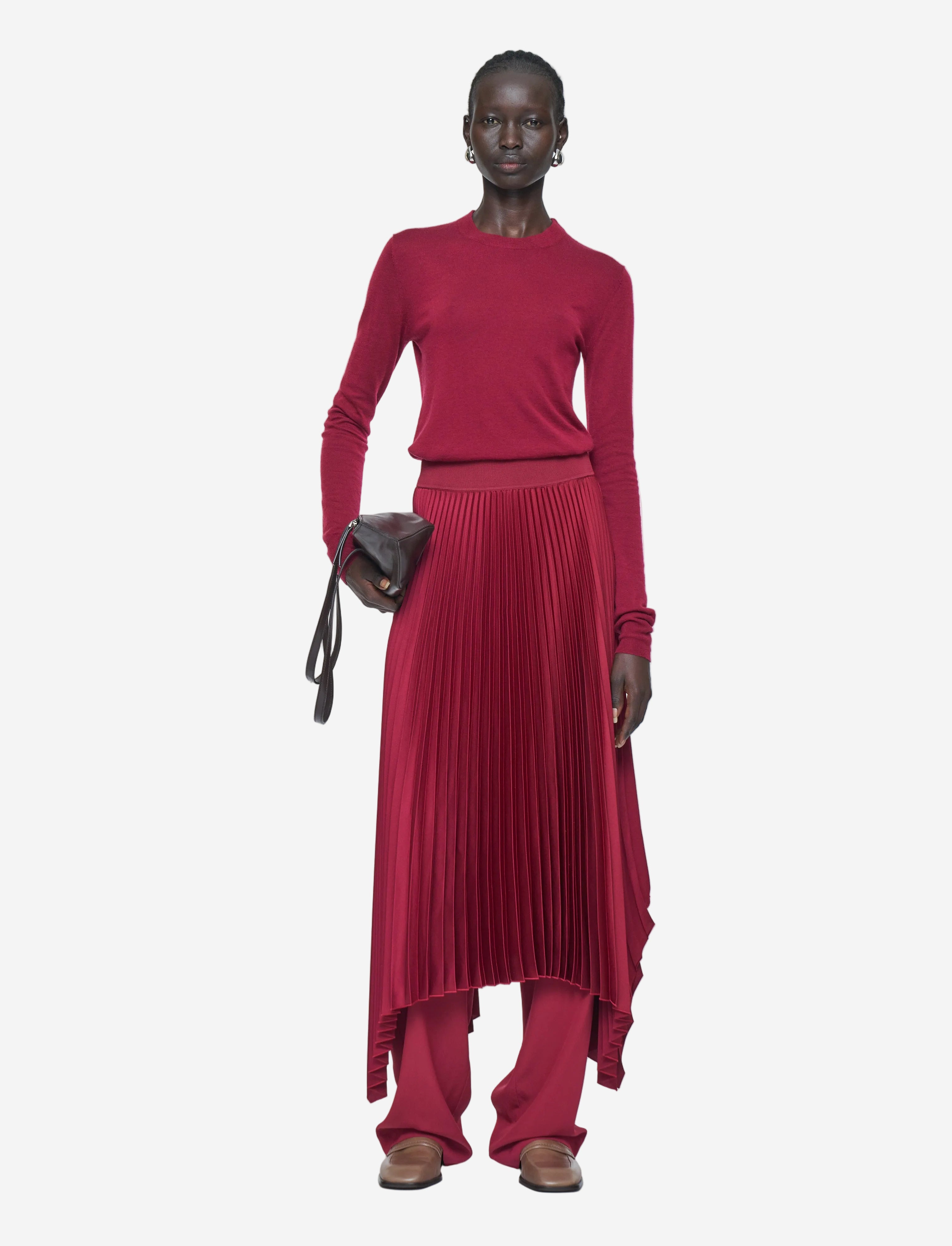 Person wearing a red outfit with a pleated skirt on a white background