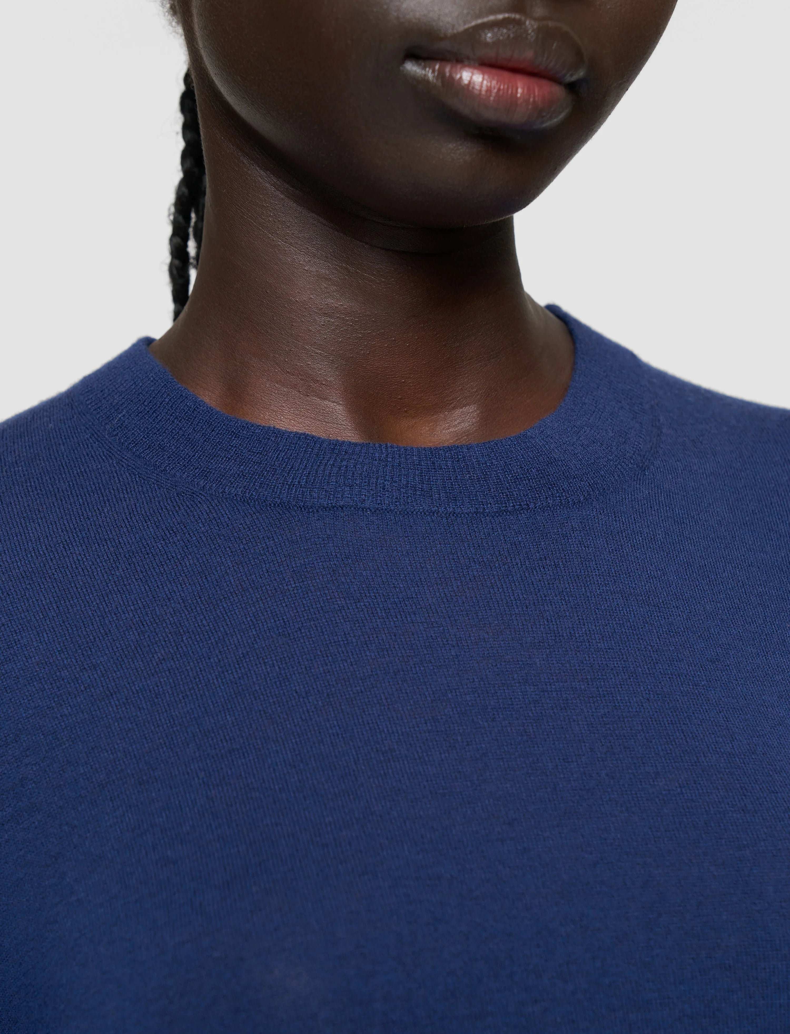Person wearing a blue sweater against a plain background