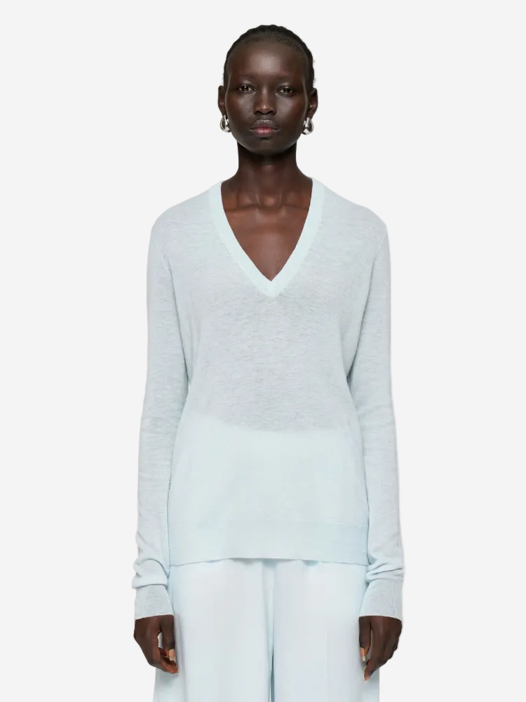 Person wearing a light gray sweater on a white background