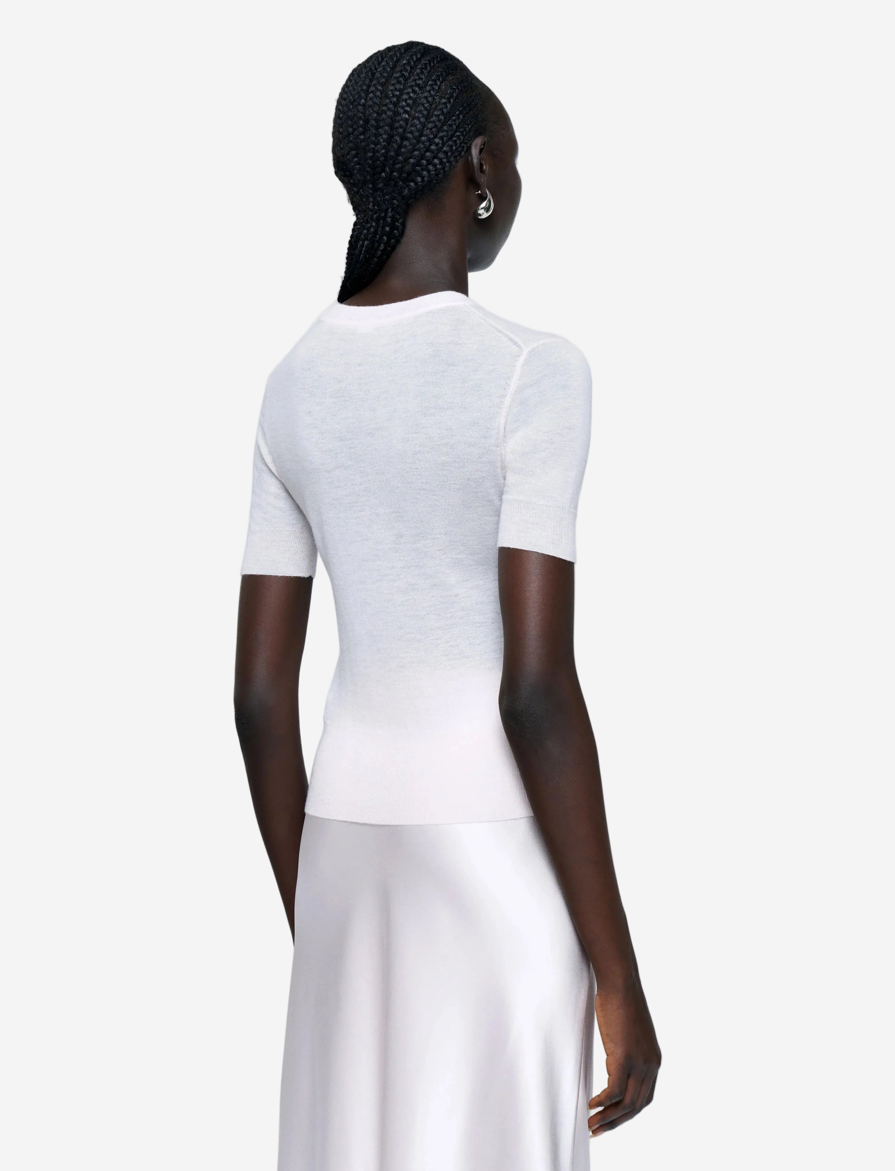 Person wearing a white outfit on a plain background