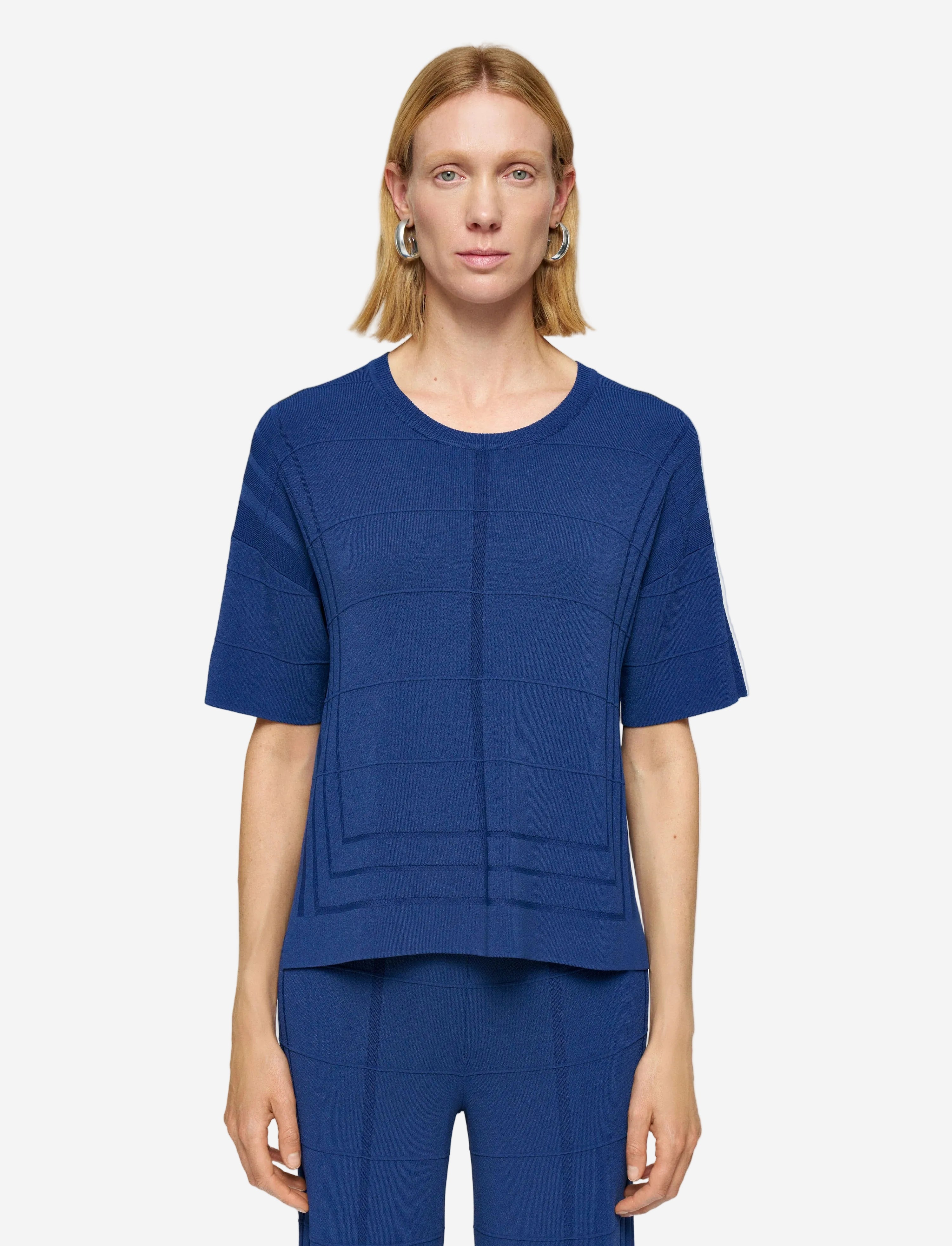 Woman wearing a blue outfit on a plain background