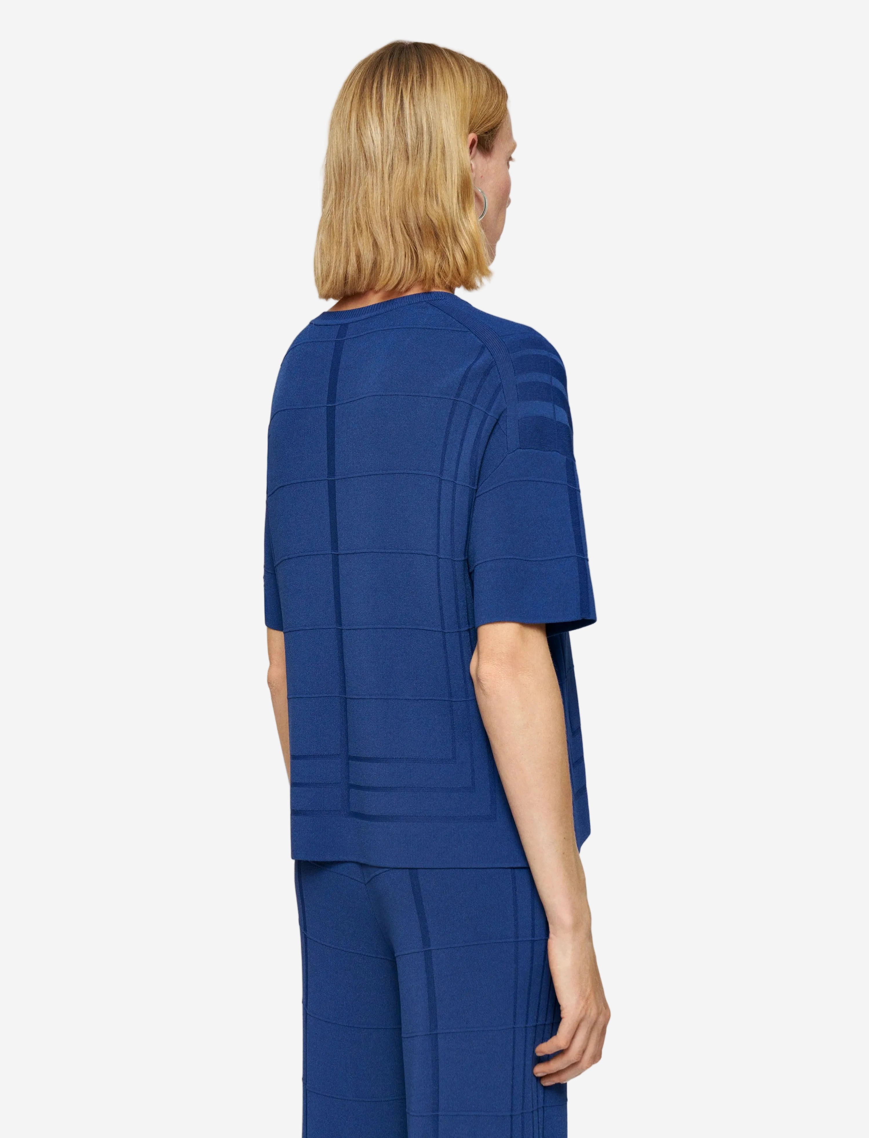 Person wearing a blue outfit with a plain background