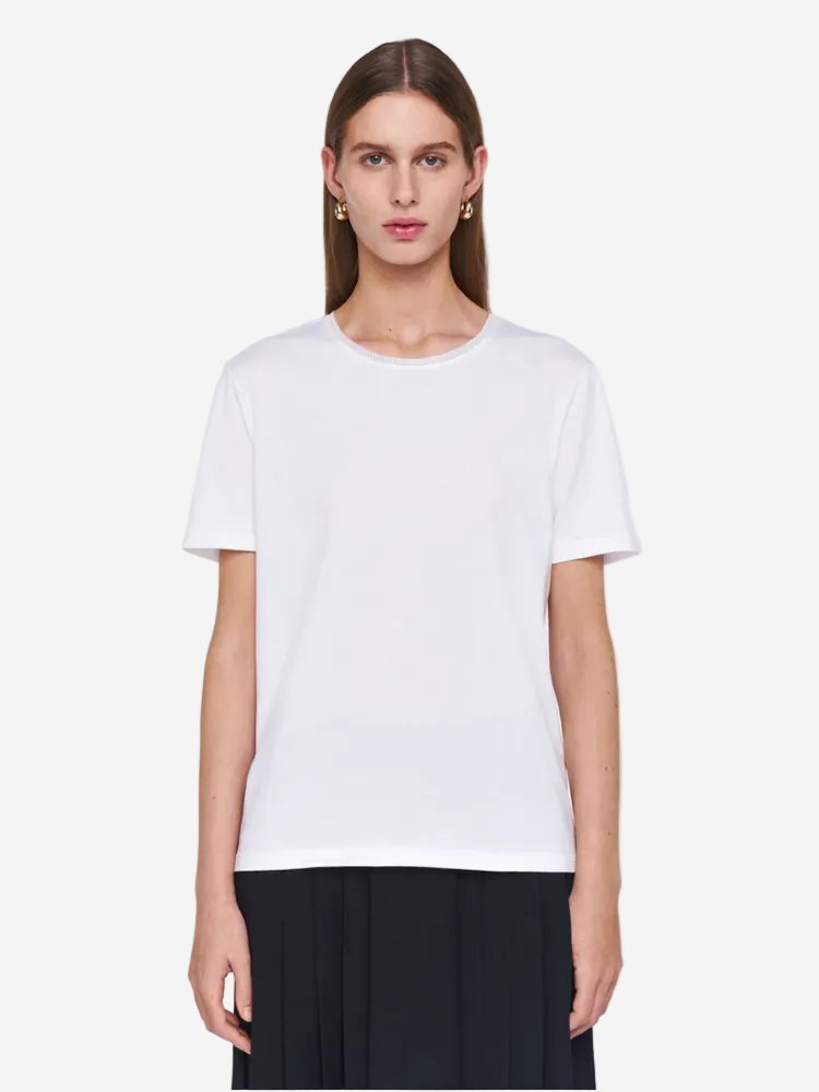 Woman wearing a plain white t-shirt against a light gray background