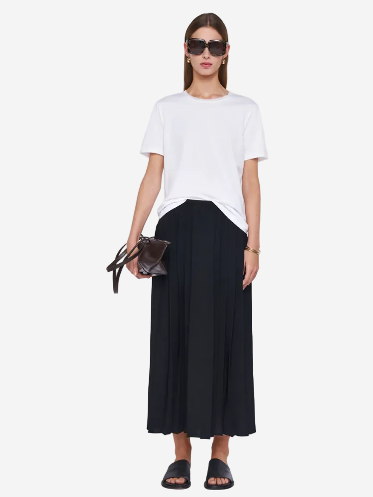 Person wearing a white t-shirt and black wide-leg pants on a plain background