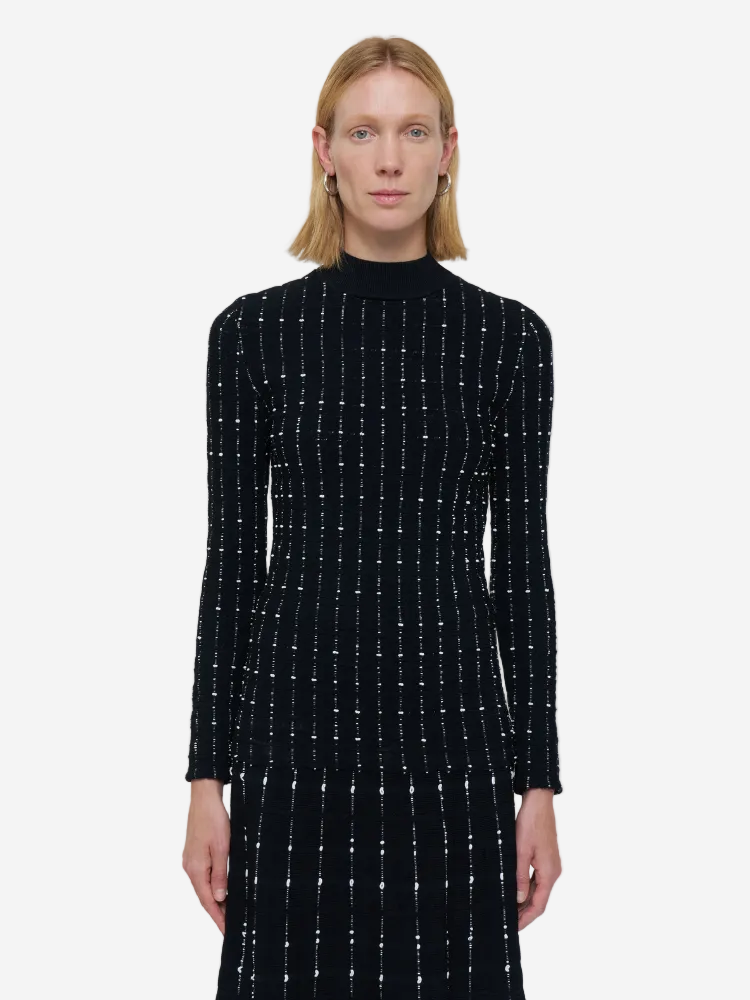 Woman wearing a black dress with white patterns on a white background