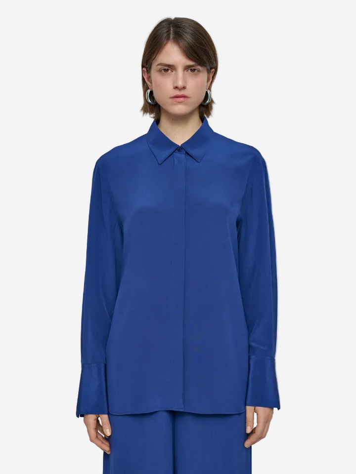 Person wearing a blue shirt on a plain background