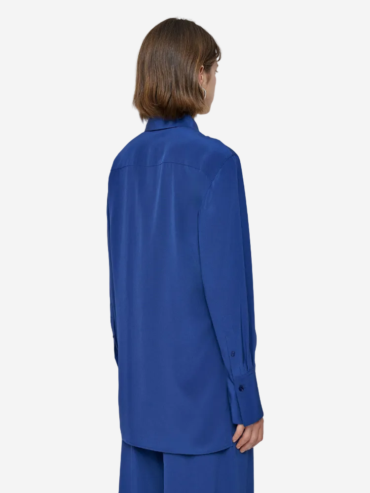 Person wearing a blue shirt and pants on a light gray background