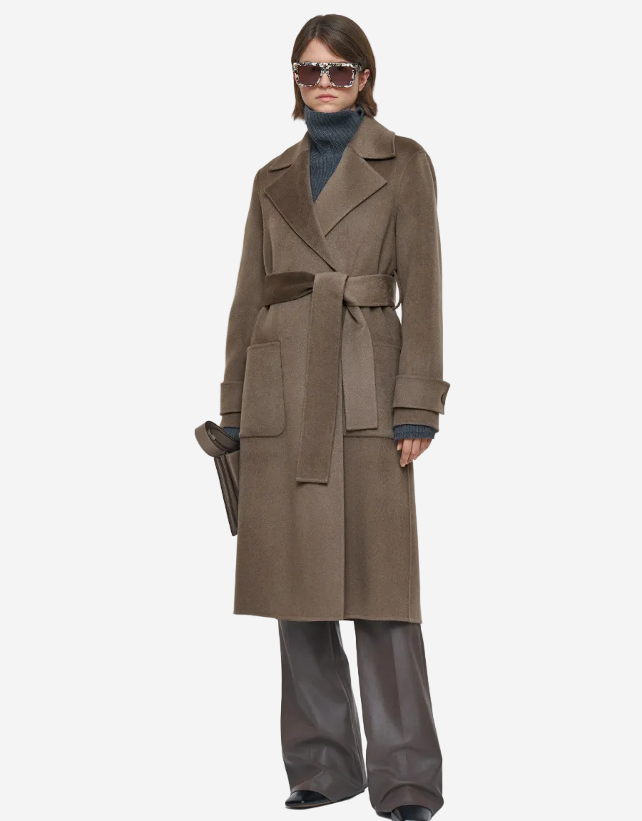 Person wearing a long brown coat on a white background
