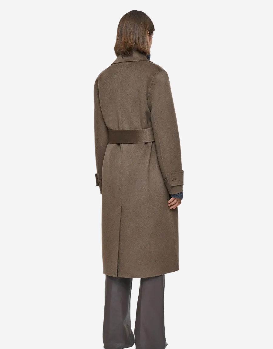 Person wearing a long brown coat on a white background