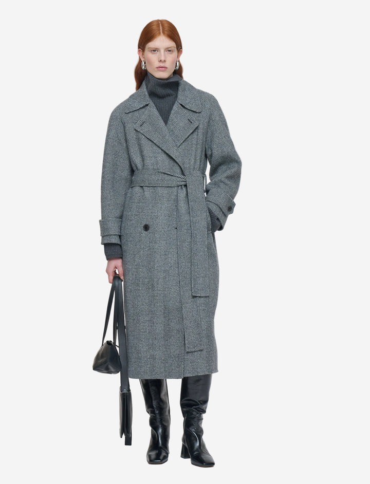 Woman wearing a gray coat with a white background