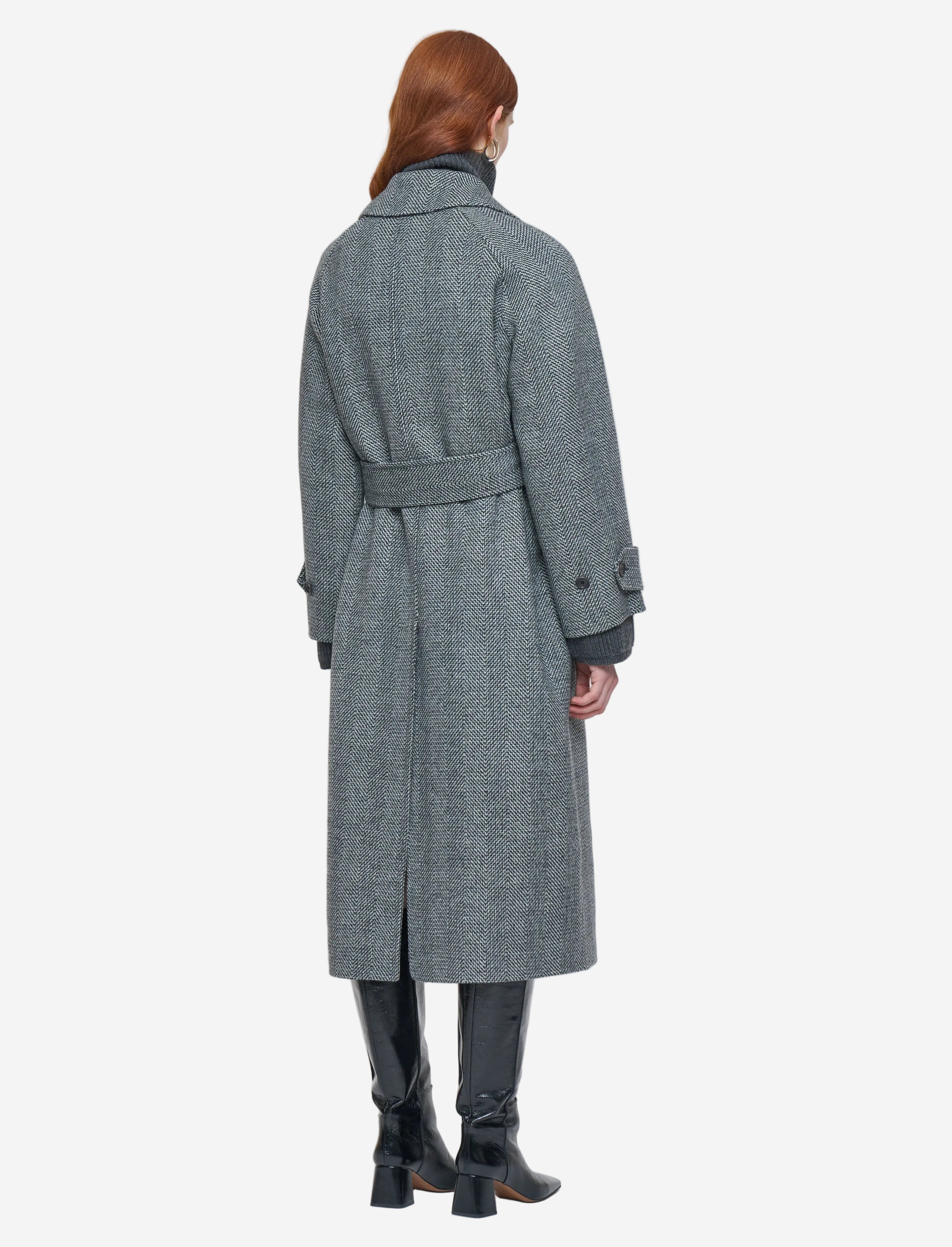 Person wearing a gray coat on a white background