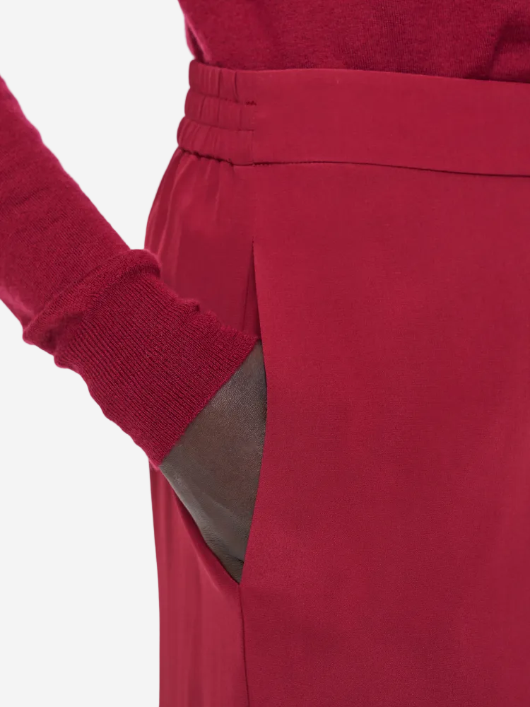 Red pants with a matching red sweater on a light gray background