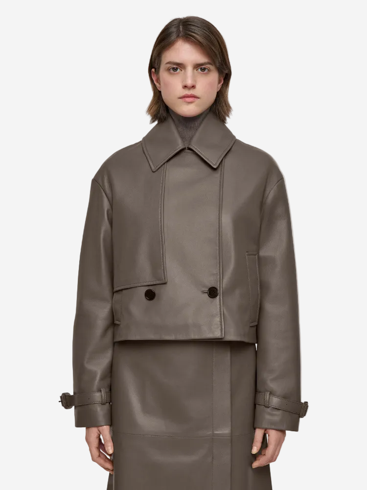 Woman wearing a brown leather jacket and skirt on a white background