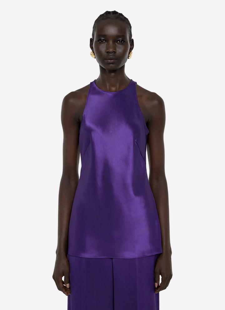 Model wearing a purple sleeveless top and pants on a white background
