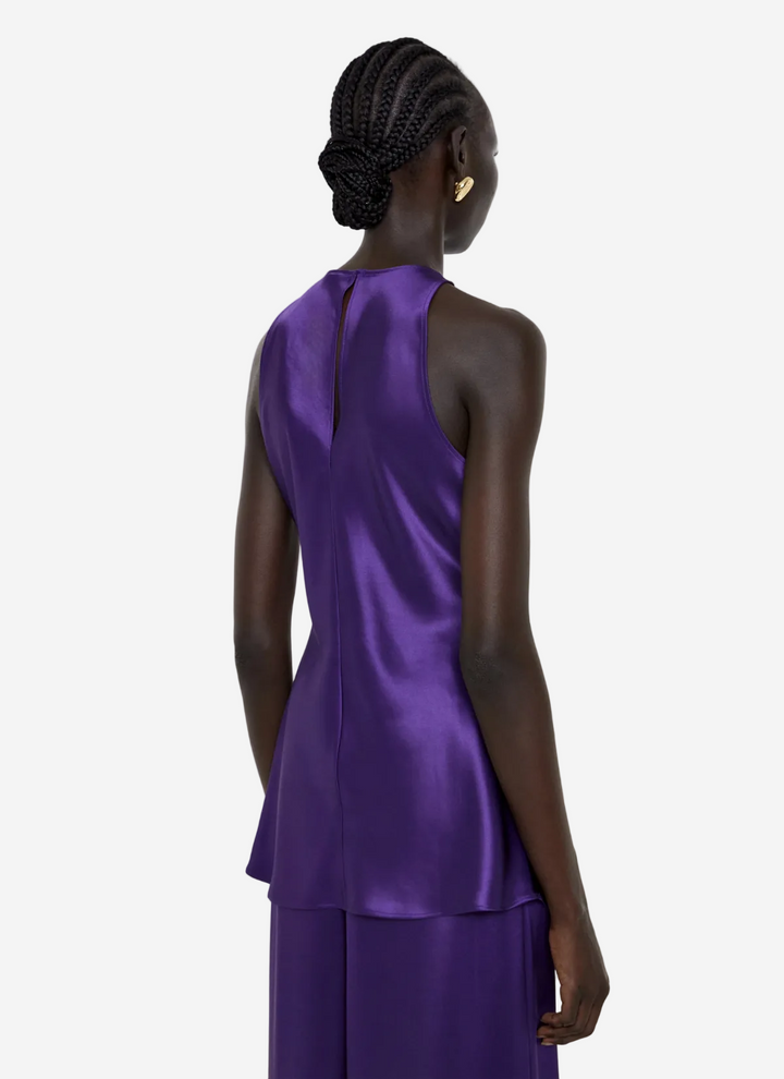 Woman wearing a purple dress with a plain background